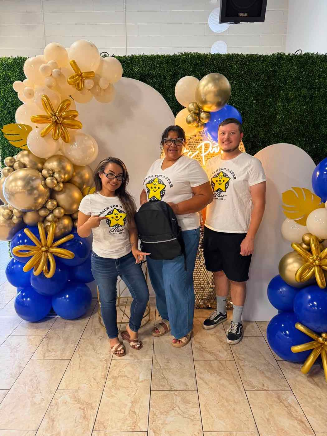 Volunteers in Reach for a Star shirts in front of a balloon arch