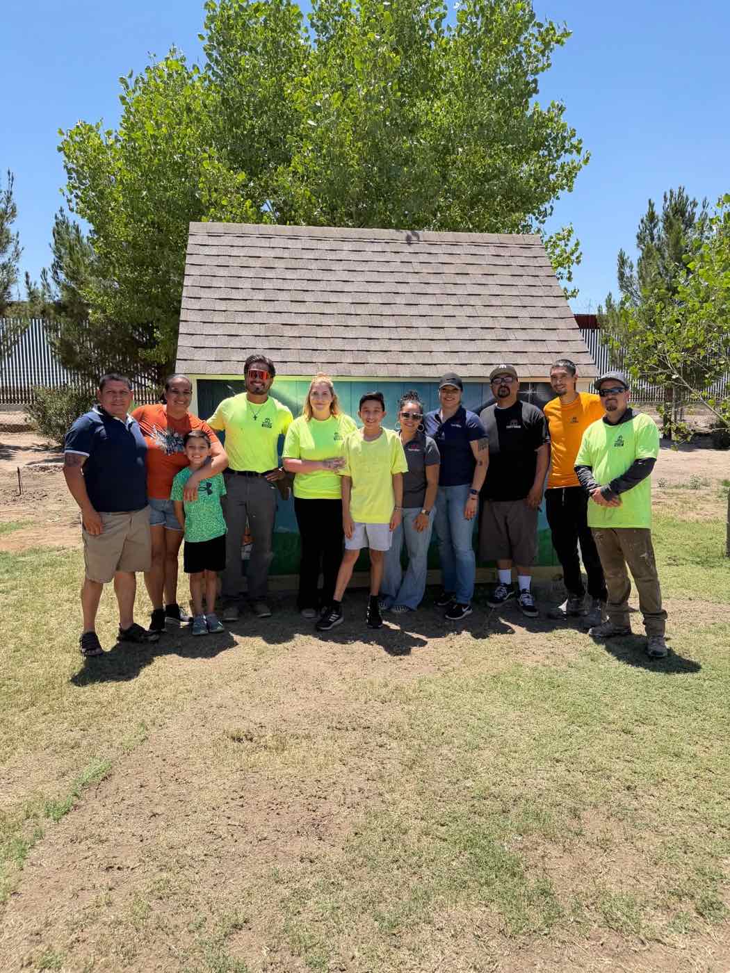 Tuff Shed El Paso team members and a family in front of a newly built, mural-painted shed
